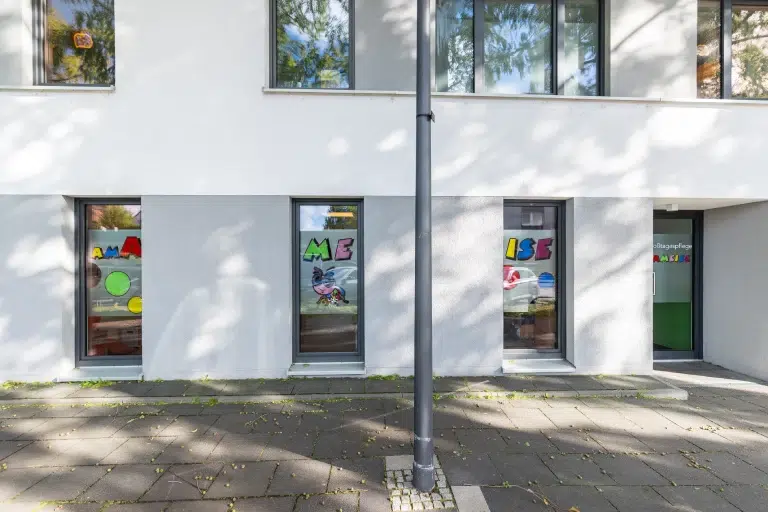 Fassaden- und Fensterbeschriftung mit farbigen Motiven an einem Gebäude, realisiert von Werbetechnik Kleiner GmbH.