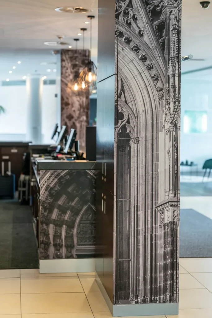 Innenansicht eines Empfangsbereichs mit vollflächig folierter Säule und Theke, ausgeführt von Werbetechnik Kleiner GmbH