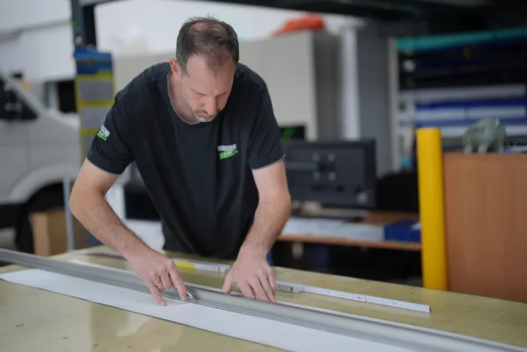 Präzise manuelle Verarbeitung und Zuschnitt von Materialien für Werbeanwendungen bei Werbetechnik Kleiner GmbH.